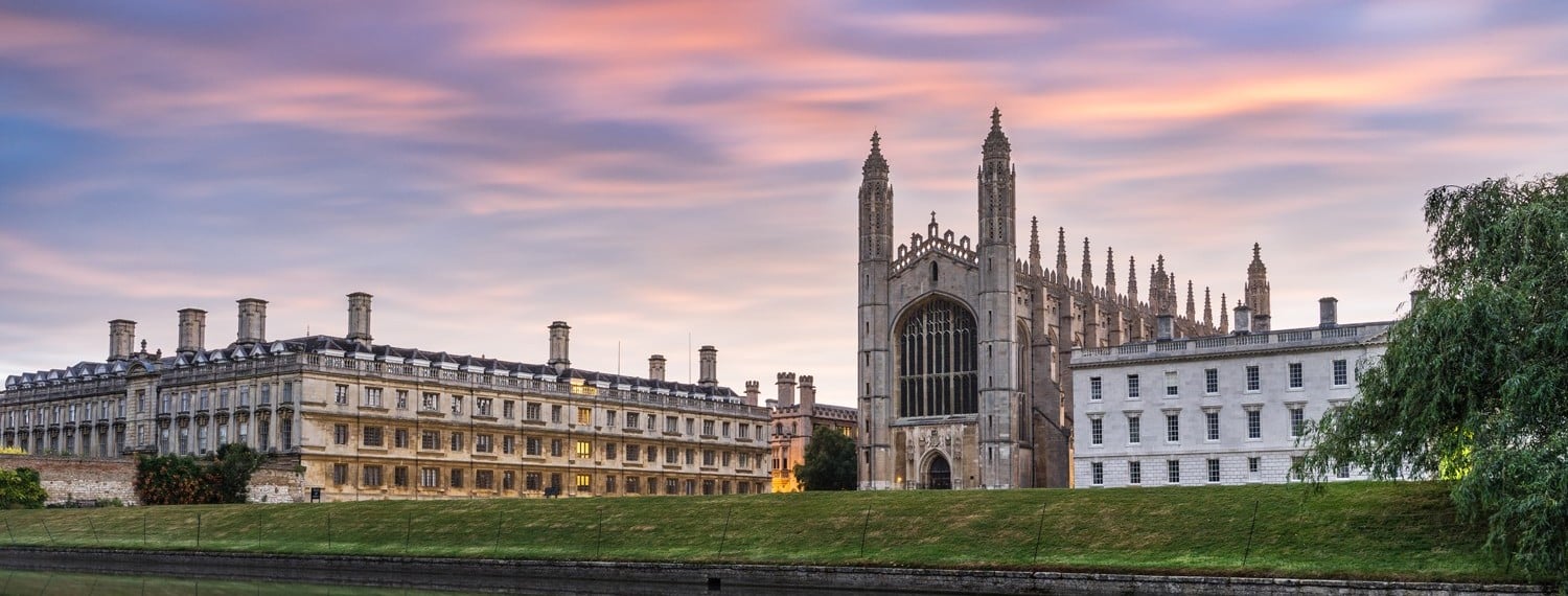 a building with towers and grass in front of it