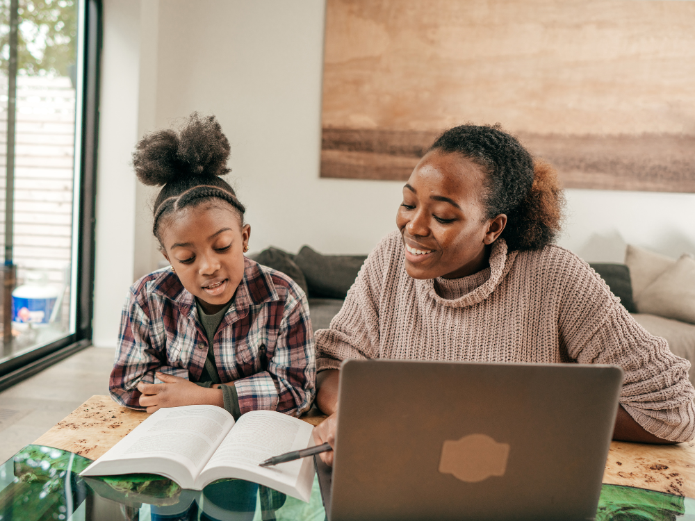 a woman and a girl looking at a book